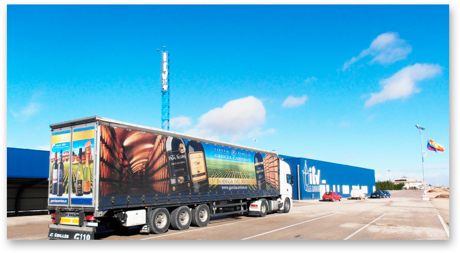 Un camión grande con un anuncio amplio en el costado esperando a pasar la ITV.