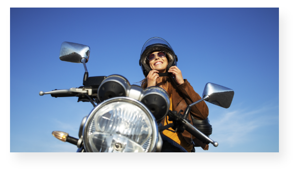 Mujer en motocicleta abrochándose el casco